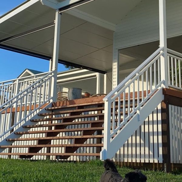 The deck stairs are designed with wide treads and natural wood texture, blending into the outdoor environment.