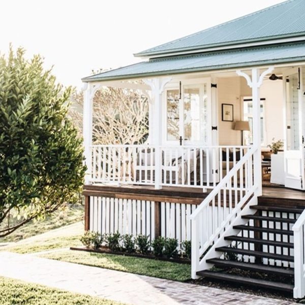 A charming set of outdoor wooden stairs leads up to a beautifully designed country-style porch.